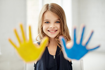 Image showing happy girl showing painted hand palms at home