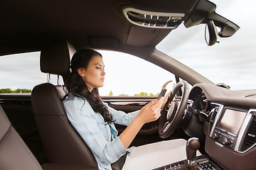 Image showing woman driving car with smarhphone