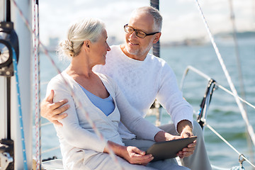 Image showing senior couple with tablet pc on sail boat or yacht