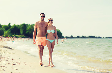 Image showing happy couple in swimwear walking on summer beach