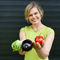 Image showing Cute blond girl presenting vegetables