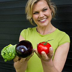 Image showing Cute blond girl presenting vegetables