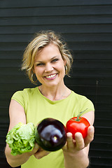 Image showing Cute blond girl presenting vegetables