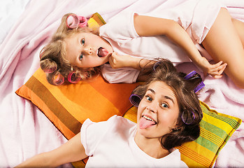Image showing Little girl with her mother playing in bed