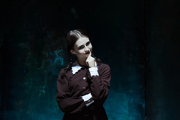 Image showing Portrait of a young smiling girl in school uniform as killer woman