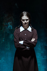 Image showing Portrait of a young girl in school uniform as killer woman