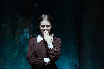 Image showing Portrait of a young smiling girl in school uniform as killer woman