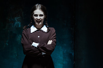 Image showing Portrait of a young smiling girl in school uniform as killer woman