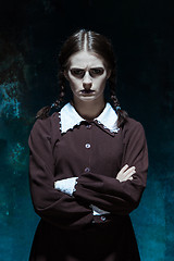 Image showing Portrait of a young girl in school uniform as killer woman