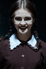 Image showing Portrait of a young smiling girl in school uniform as killer woman