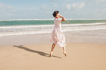 Image showing Woman walking on the beach sand