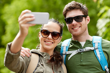 Image showing couple with backpacks taking selfie by smartphone