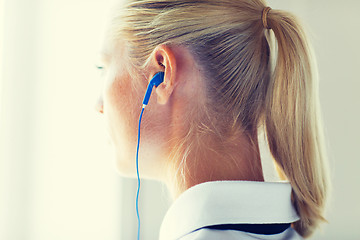 Image showing close up of woman in earphones at home