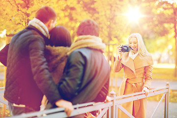 Image showing group of friends with photo camera in autumn park