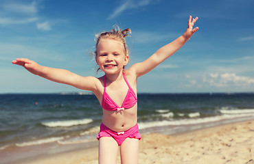 Image showing happy little girl in swimwear having fun on beach