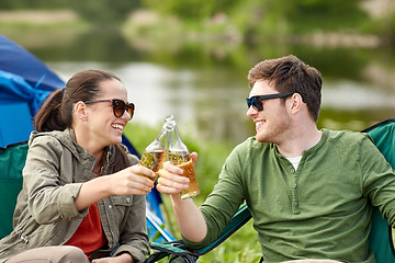 Image showing happy couple clinking drinks at campsite tent