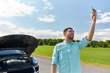 Image showing man with smartphone and broken car at countryside