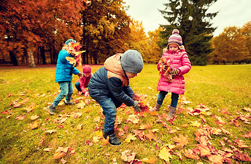 Image showing group of children collecting leaves in autumn park