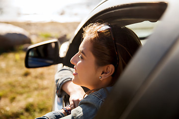 Image showing happy teenage girl or young woman in car