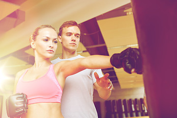 Image showing woman with personal trainer boxing in gym