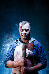 Image showing Bloody Halloween theme: crazy killer as butcher with an ax