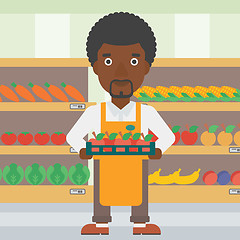 Image showing Supermarket worker with box full of apples.