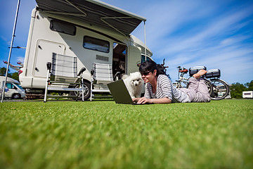 Image showing Woman on the grass with a dog looking at a laptop