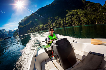 Image showing Woman driving a motor boat