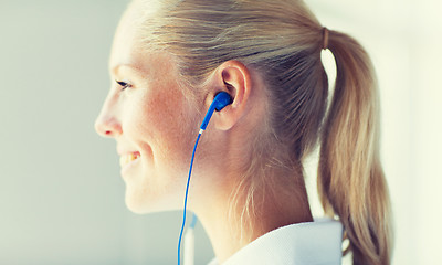 Image showing close up of happy woman in earphones at home