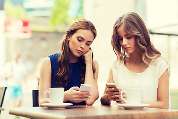 Image showing women with smartphones and coffee at outdoor cafe