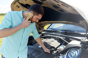 Image showing man with broken car calling on smartphone