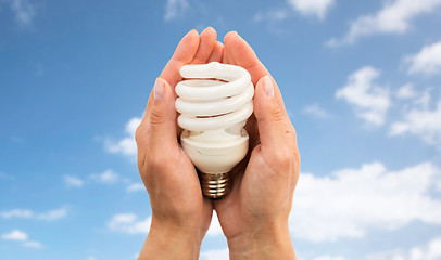 Image showing close up of hands holding energy saving lightbulb