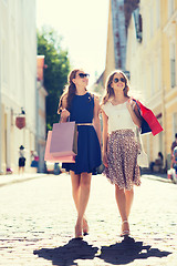 Image showing happy women with shopping bags walking in city 