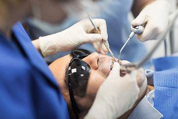 Image showing close up of dentists treating teeth at clinic