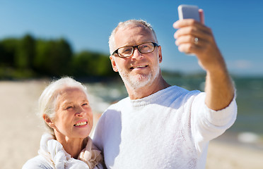 Image showing happy senior couple hugging on summer beach