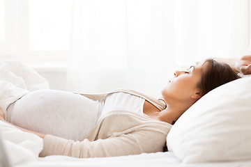 Image showing happy pregnant woman sleeping in bed at home