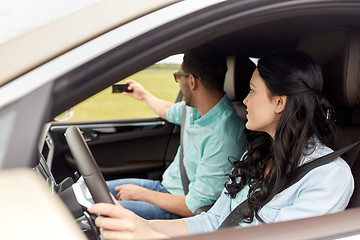 Image showing happy couple in car taking selfie with smartphone