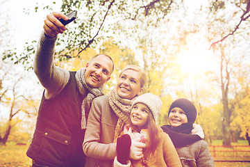 Image showing happy family with camera in autumn park