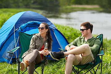 Image showing happy couple drinking beer at campsite tent