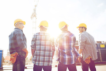 Image showing group of smiling builders in hardhats outdoors