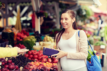 Image showing pregnant woman with wallet buying food at market