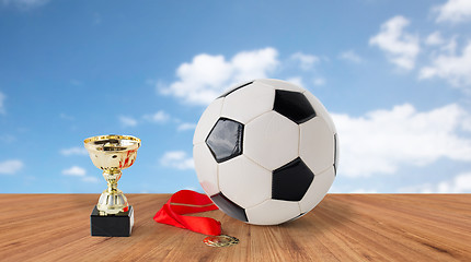 Image showing close up of football ball, golden cup and medal