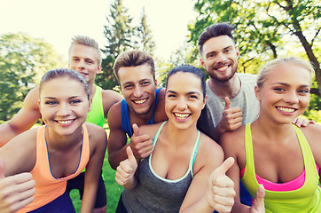 Image showing group of happy sporty friends showing thumbs up