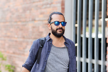 Image showing man with backpack walking along city street