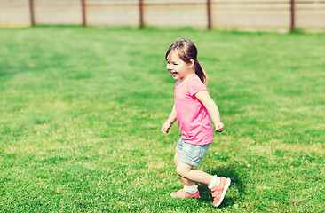 Image showing happy little girl running on green summer field