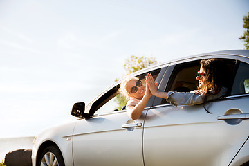 Image showing happy teenage girls or women in car at seaside