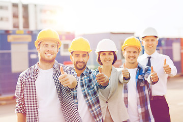 Image showing group of smiling builders in hardhats outdoors