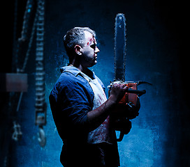 Image showing Bloody Halloween theme: crazy killer as butcher with electric saw