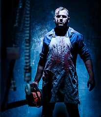 Image showing Bloody Halloween theme: crazy killer as butcher with electric saw