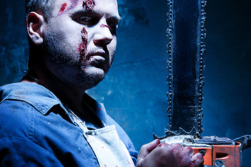 Image showing Bloody Halloween theme: crazy killer as butcher with electric saw